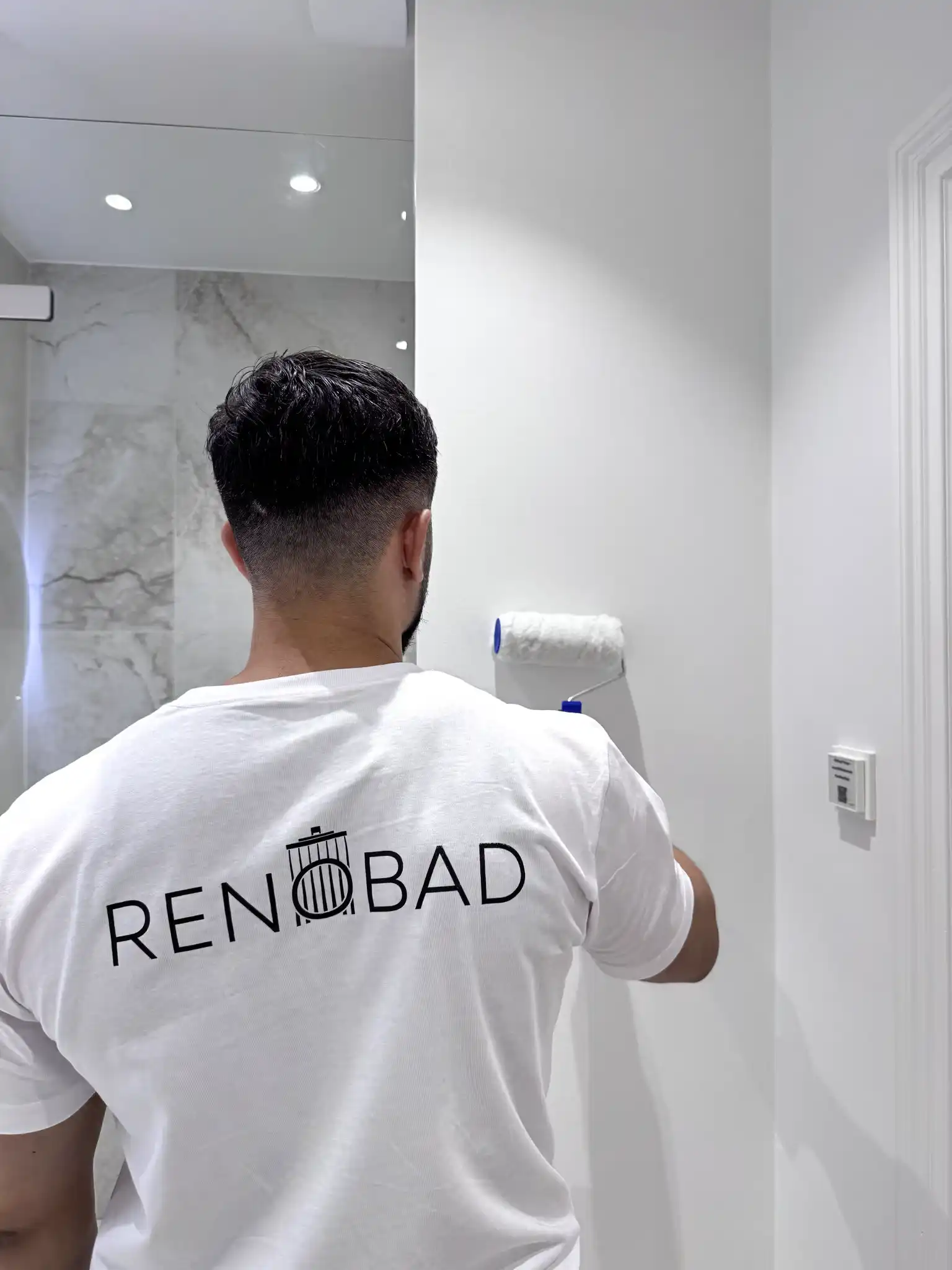 Renobad medarbejder i gang med at male et badeværelse