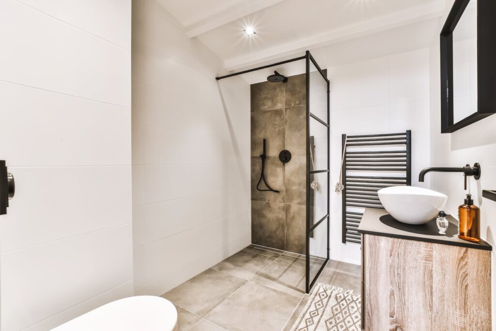 Renovering af badeværelse i Hellerup med sort glasvæg og egetræsmøbel