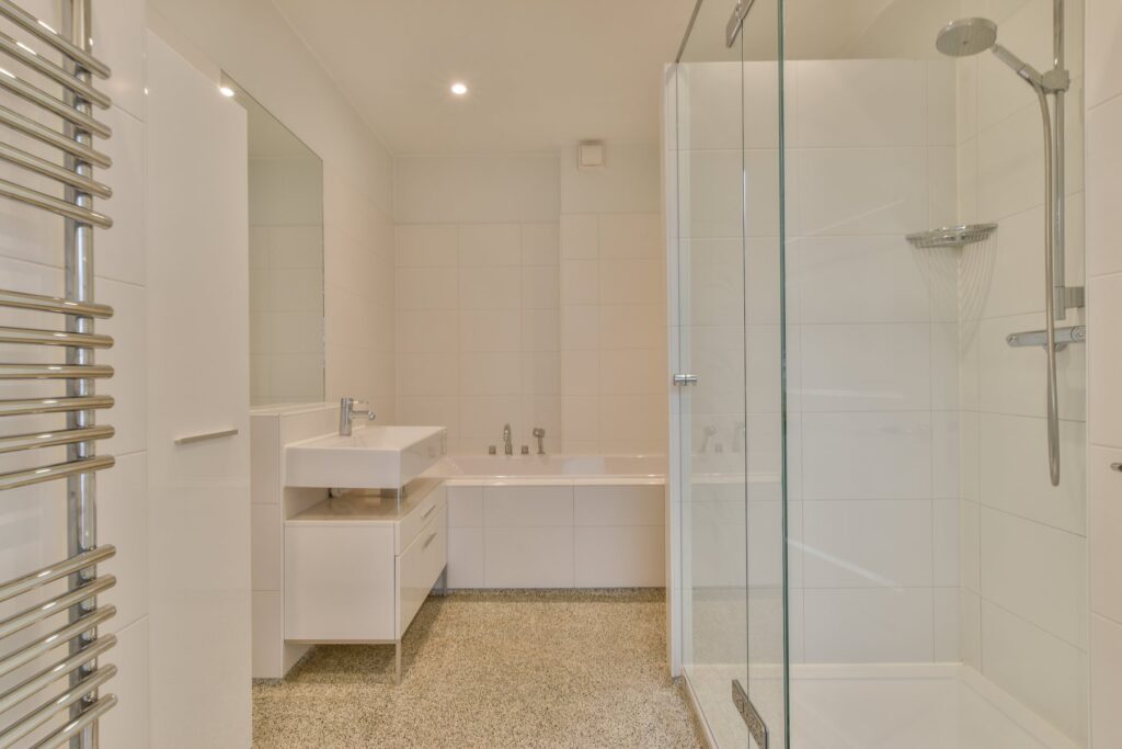 Renovering af badeværelse i Næstved med glasbruser og lyst vaskemøbel